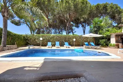 a swimming pool with blue chairs and trees at Spacious Retreat with Prime Location, Private pool, snooker, free AC Wifi in Quarteira