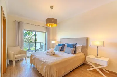 a bedroom with a bed with a stuffed animal on it at Jardins da Marina BI Albufeira Marina in Albufeira