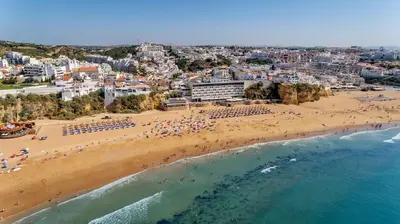 a beach with a bunch of chairs on it at Happy House in Clube Albufeira in Albufeira