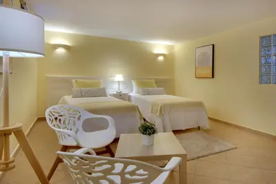 a room with two beds and a table and chairs at Eagle Eye Villa in Albufeira