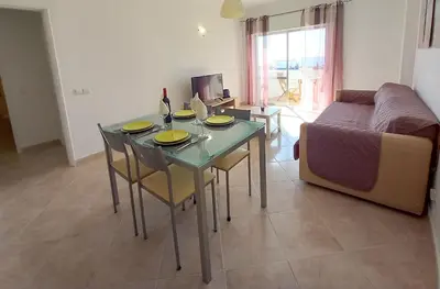 a living room with a table with chairs and a couch at T1 PonteMira 6 50M PRAIA VISTA MAR in Quarteira