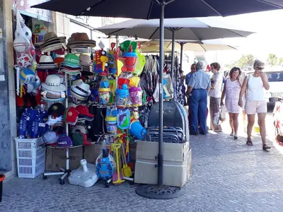a group of people walking around a market with hats at T1 PonteMira 6 50M PRAIA VISTA MAR in Quarteira