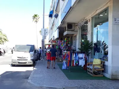 a man and a child standing in front of a store at T1 PonteMira 6 50M PRAIA VISTA MAR in Quarteira