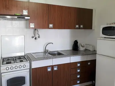 a small kitchen with a stove and a sink at Torre 6- Vista Cidade, Aconchegante, 80mt Praia, Wifi in Quarteira