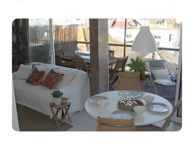 a white couch and a table on a balcony at Panoramic Faro Apartment in Faro