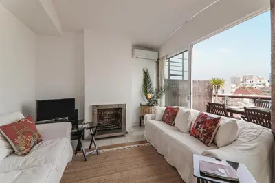 a living room with two white couches and a fireplace at Panoramic Faro Apartment in Faro