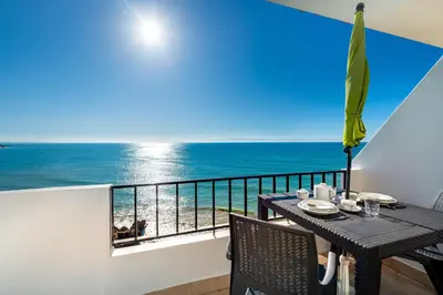 a kitchen and living room with a table and a couch at Sunset Azul - Sea View - Free Wifi - By Bedzy in Albufeira