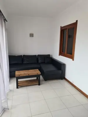 a living room with a black couch and a coffee table at 1 bedroomed Apartment - Ocean View - Oura - Beach in Albufeira