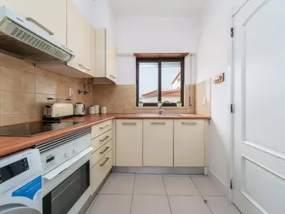 a kitchen with white cabinets and a window at 1 bedroomed Apartment - Ocean View - Oura - Beach in Albufeira