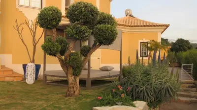 two chairs and a table on a balcony with a sunset at Casa Das Palmeiras in Loulé