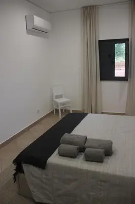 a bedroom with a large bed with three pillows on it at Quinta do Sr. Cabrita in Albufeira