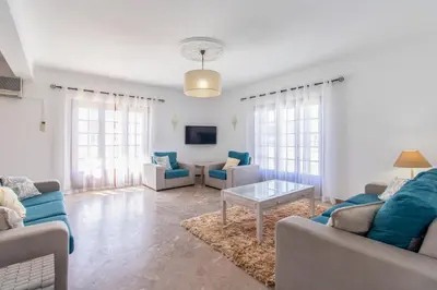 a living room with two couches and a tv at Villa Brisa do Mar in Galé