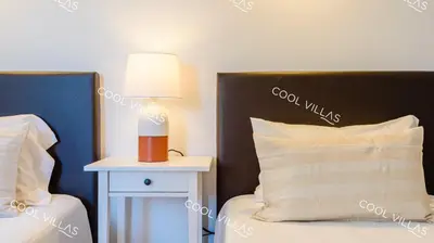 a bedroom with a bed and a lamp on a night stand at Villa Margarida - heatable pool & city center in Albufeira