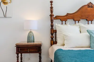 a bedroom with a bed and a table with a lamp at Villa Margarida - heatable pool & city center in Albufeira