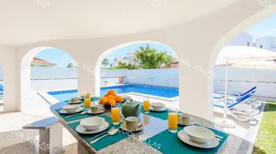 a villa with a pool and a table with food at Villa Margarida - heatable pool & city center in Albufeira