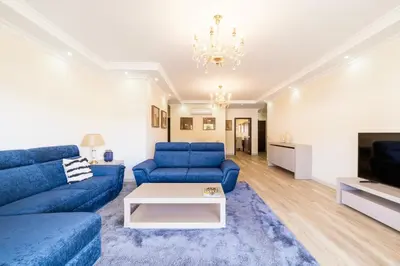 a living room with blue couches and a tv at Histórical City Center Penthouse Albufeira in Albufeira