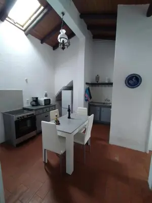 a kitchen with a white table and white chairs at Pérola de Sandy in Paderne
