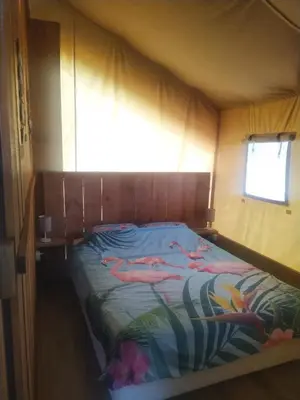 a bed in a small room with a window at Pérola de Sandy in Paderne
