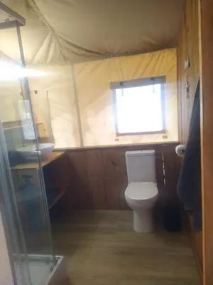a small bathroom with a toilet and a window at Pérola de Sandy in Paderne