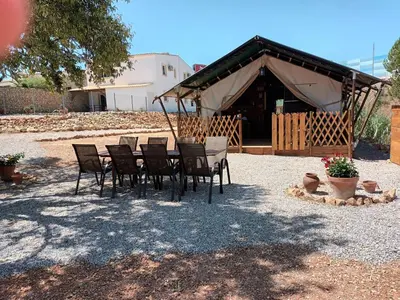 a group of chairs and a table in front of a tent at Pérola de Sandy in Paderne