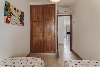 two twin beds in a room with a window at Old Village Vilamoura in Quarteira