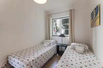 two beds in a small room with a window at Old Village Vilamoura in Quarteira