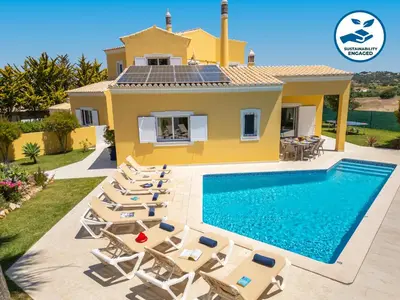 a villa with a swimming pool in front of a house at Villa Palms by Algarve Vacation in Albufeira