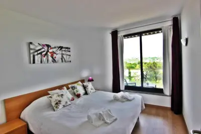 a bedroom with a bed and a large window at Residences Golf Club Apartment in Quarteira