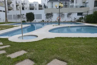a swimming pool in front of a building at Apartamento próximo da Marina Vilamoura c/piscina e estacionamento in Vilamoura