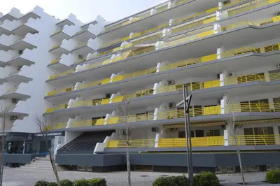 an apartment building with yellow balconies at Apartamento próximo da Marina Vilamoura c/piscina e estacionamento in Vilamoura
