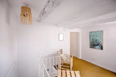 a white room with a staircase and a painting on the wall at Old Charming Faro Apartment in Faro