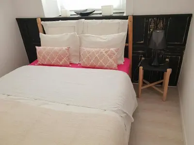 a bedroom with a large bed with pink and white pillows at Old Charming Faro Apartment in Faro