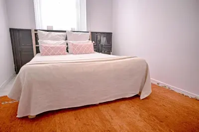 a bedroom with a large bed with pink and white pillows at Old Charming Faro Apartment in Faro