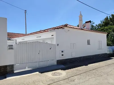 a white building with a gate and a fence at Casa Sequeira in Albufeira