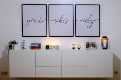 a white cabinet with four pictures on the wall at AL-Dream Oura Estrela Apartments - CC in Albufeira