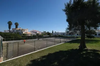 a person is playing tennis on a tennis court at AL-Dream Oura Estrela Apartments - CC in Albufeira