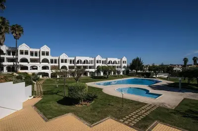 a large white building with a swimming pool in a yard at AL-Dream Oura Estrela Apartments - CD in Albufeira