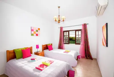 two beds in a room with pink and white at Villa Ushuaia by Algarve Vacation in Guia