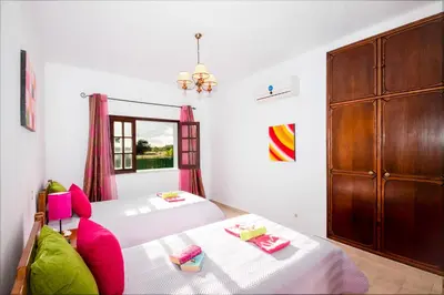 a bedroom with two beds and a large cabinet at Villa Ushuaia by Algarve Vacation in Guia