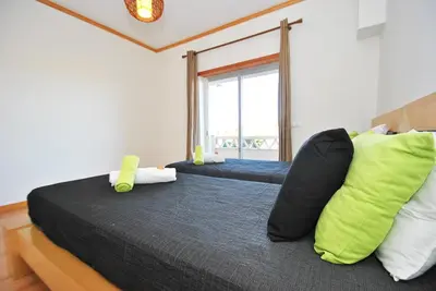 two beds in a room with a window at Townhouse Mar 2 by Algarve Vacation in Albufeira