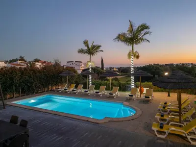 a swimming pool with chairs and umbrellas at Villa Florida by Algarve Vacation in Albufeira