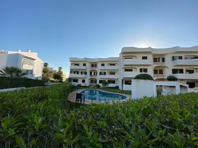 a large building with a swimming pool in front of it at Casa de Vilamoura in Vilamoura