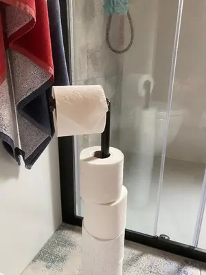 a stack of toilet paper in front of a shower at Casa felix in Loulé