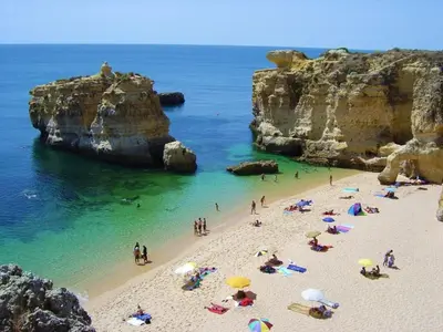 a group of people on a beach with umbrellas at Villa Amendoeiras 52 in Albufeira