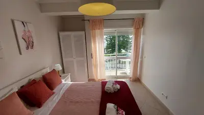 a bedroom with a bed with red pillows and a window at 3 bedroom apartment in Oura Albufeira with amazing pool at walking distance to beach, strip and old town, WIFI and AC, private condo in Albufeira