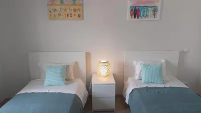 a bedroom with two beds and a table with a lamp at 3 bedroom apartment in Oura Albufeira with amazing pool at walking distance to beach, strip and old town, WIFI and AC, private condo in Albufeira
