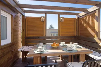a wooden porch with a wooden table and chairs at Cabana Gardenhouse in Loulé