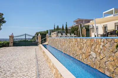 a swimming pool in front of a house at Cabana Gardenhouse in Loulé