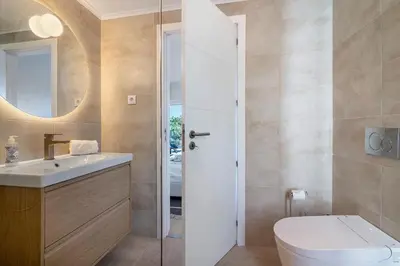 a bathroom with a toilet and a sink and a mirror at Apartment Dansk in Almancil