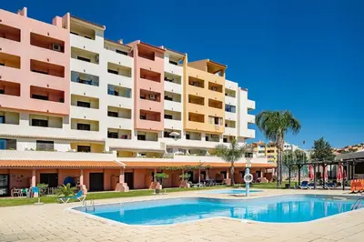 a hotel with a swimming pool in front of a building at LovelyStay - Bela Vista 3BDR Duplex Penthouse with Pool in Albufeira